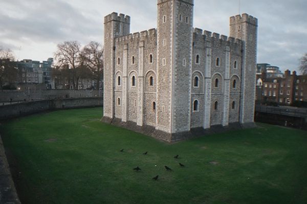 Tower of London keep rising above the medieval walls on a bright morning